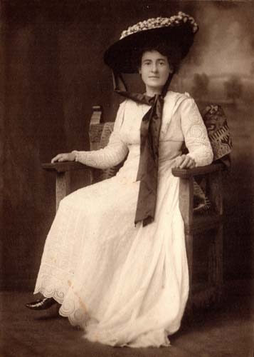 image of lady from early 1900 posing in white dress and wide brimmed hat