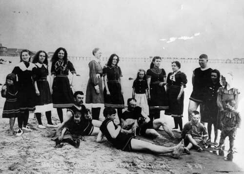 group of people posing on the beach around 1890