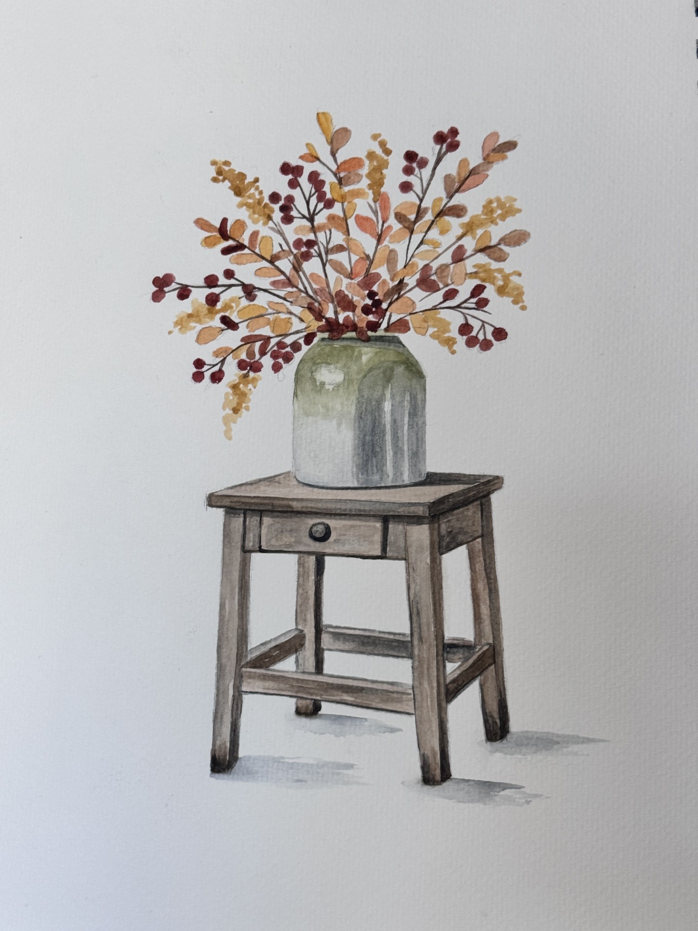 Watercolor painting of a green vase with autumnal branches on a small wooden table with a single drawer, against a plain white background—an ideal subject for an autumn painting during your next watercolor class.