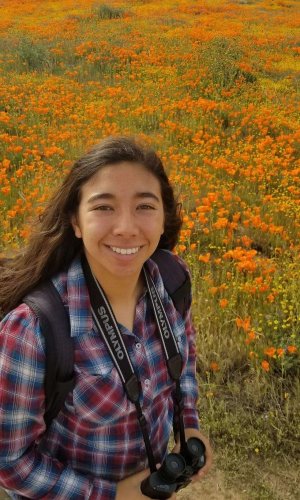 girl smiling in front of field of flowers